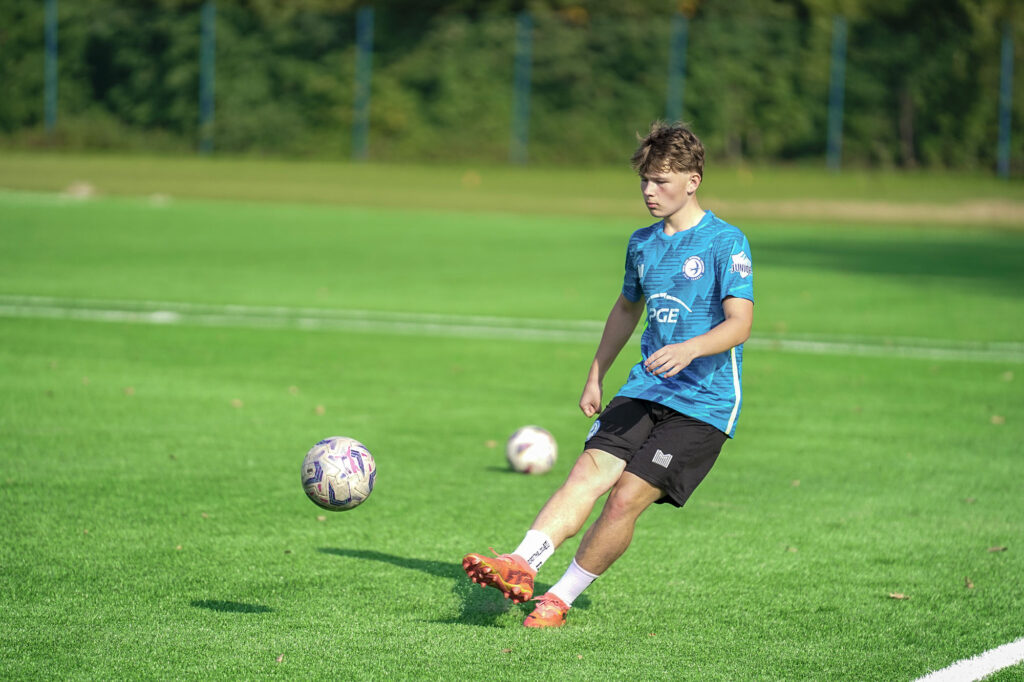 Zawodnik juniorów młodszych wykonuje podanie piłki.