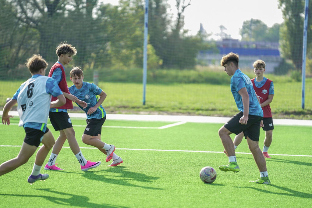 Zawodnicy juniorów młodszych w akcji z piłką podczas gry treningowej.